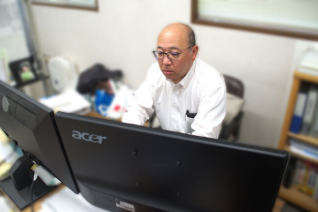 パソコンを使ってホームページや新規工事の図面を確認する後藤寛之社長