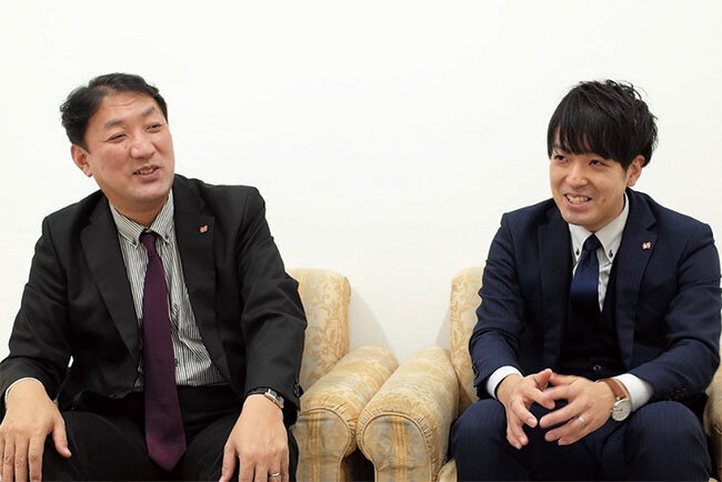 開志専門職大学の高野真司総務部長（左）と総務課の菅原悠矢さん