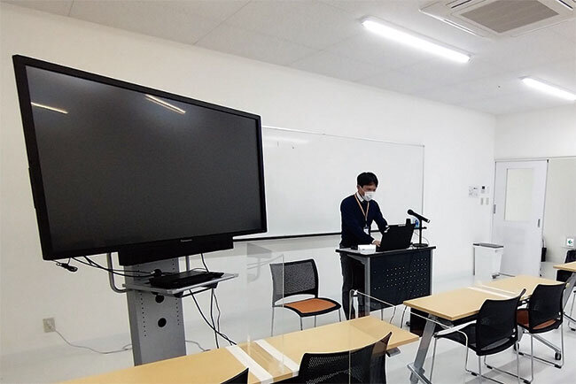 カメラや大型モニターが配置された教室。遠隔での講義も可能だ