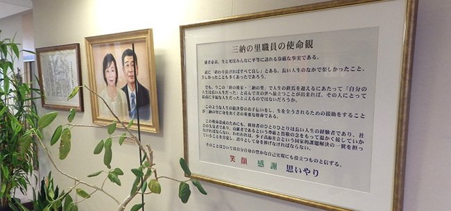 施設内に掲げられた相澤潔初代理事長夫妻の肖像画と経営理念の額