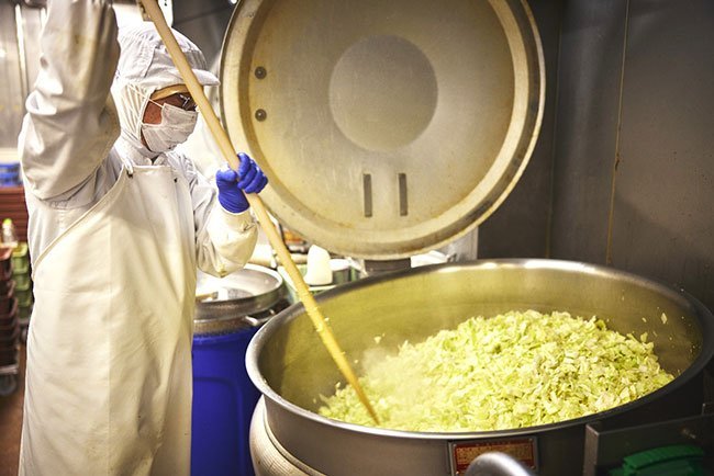 巨大な釜20台を使って毎日1万5,000人分の給食を作る