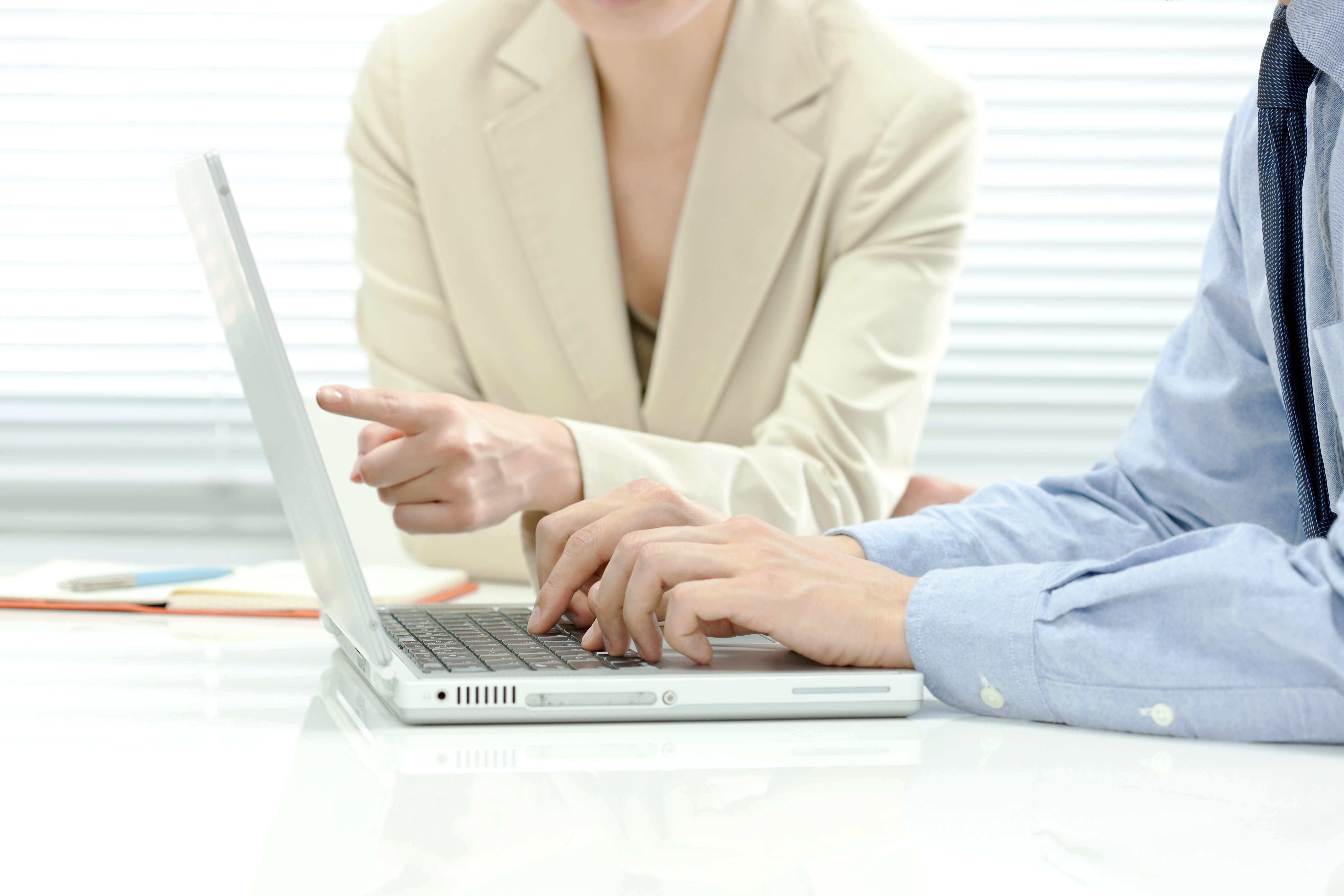 2名のビジネスパーソンがノートPCを確認している様子