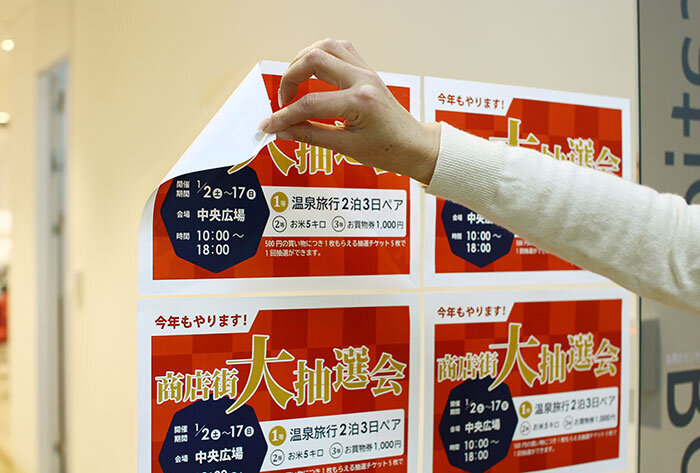 窓ガラスに貼られたエヴァタックの大抽選会の案内シール