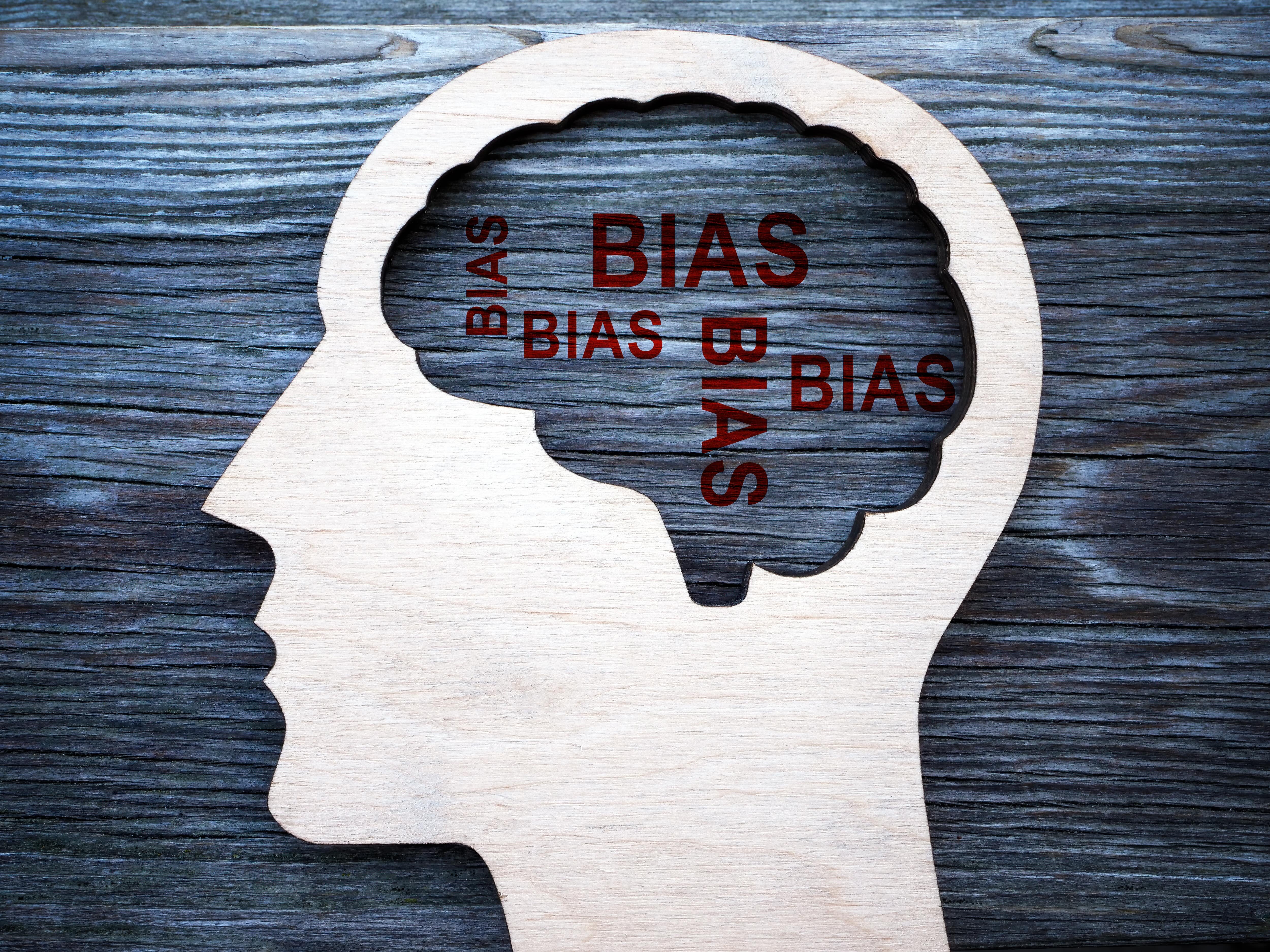 人の頭部シルエットの中に「BIAS(バイアス)」の文字が並ぶイメージ。 リフレーミングを行う際に注意すべき思い込みや認知バイアスを象徴する。