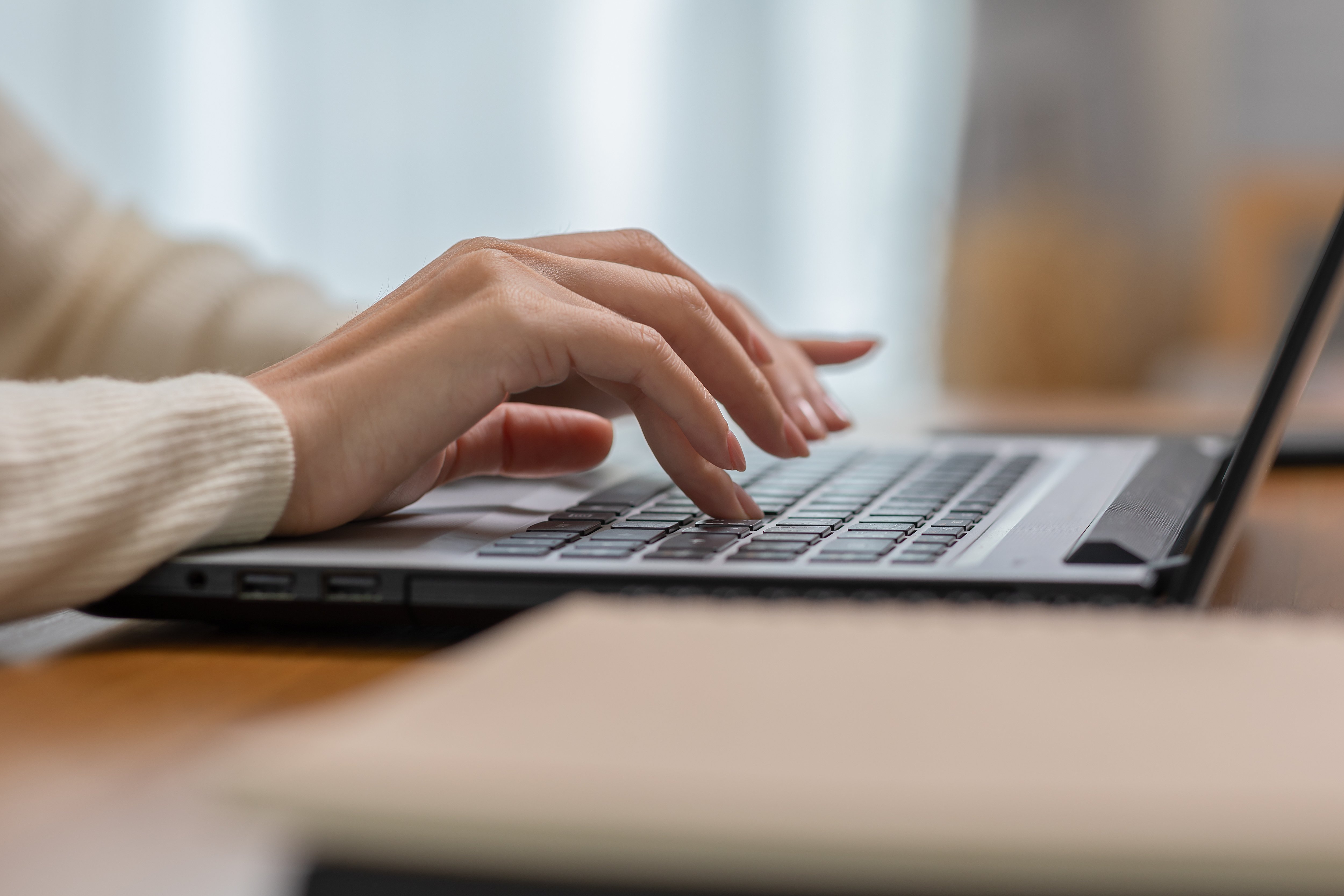 ノートPCで作業するビジネスパーソンの手元