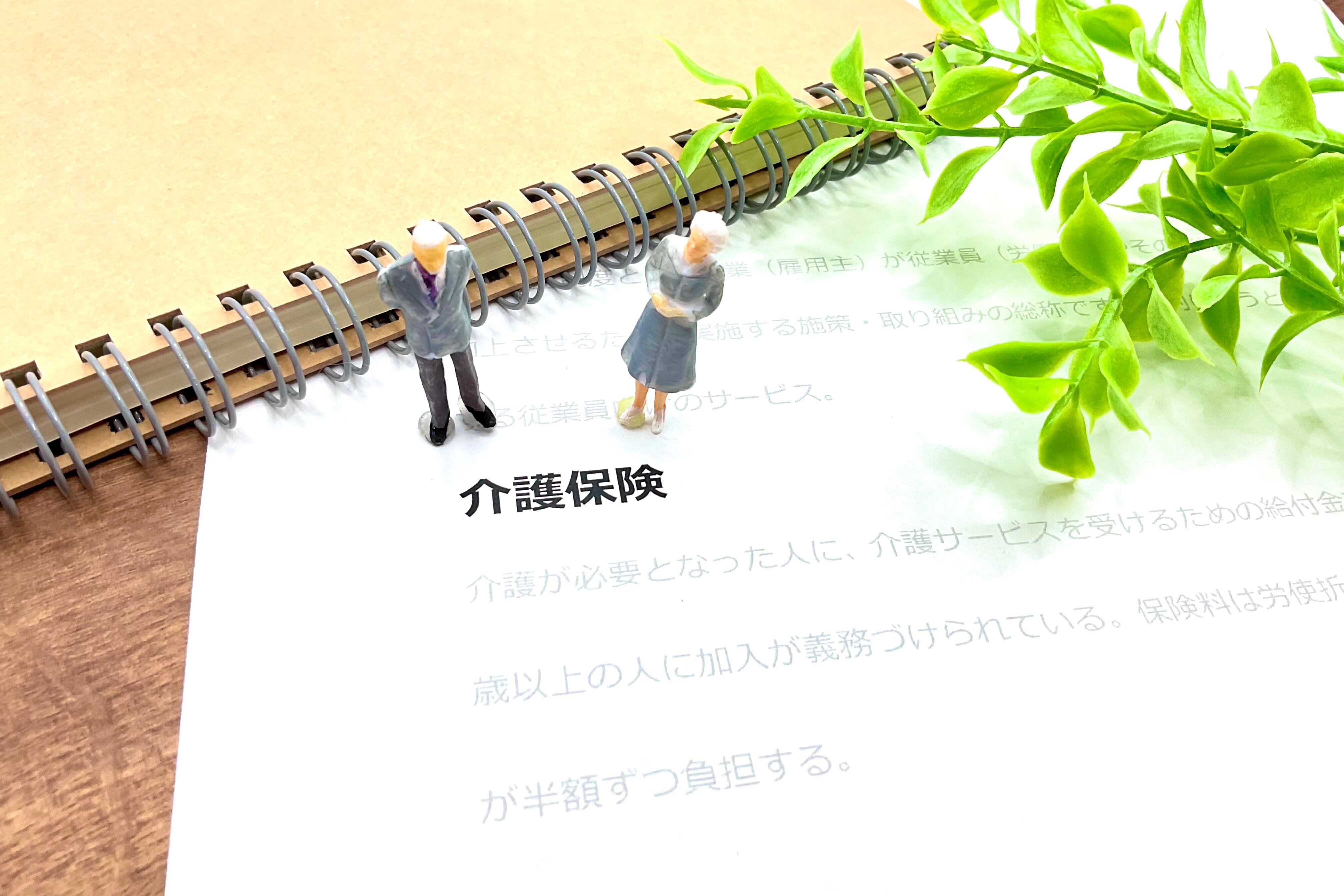 介護保険と記載のある紙と高齢の置物