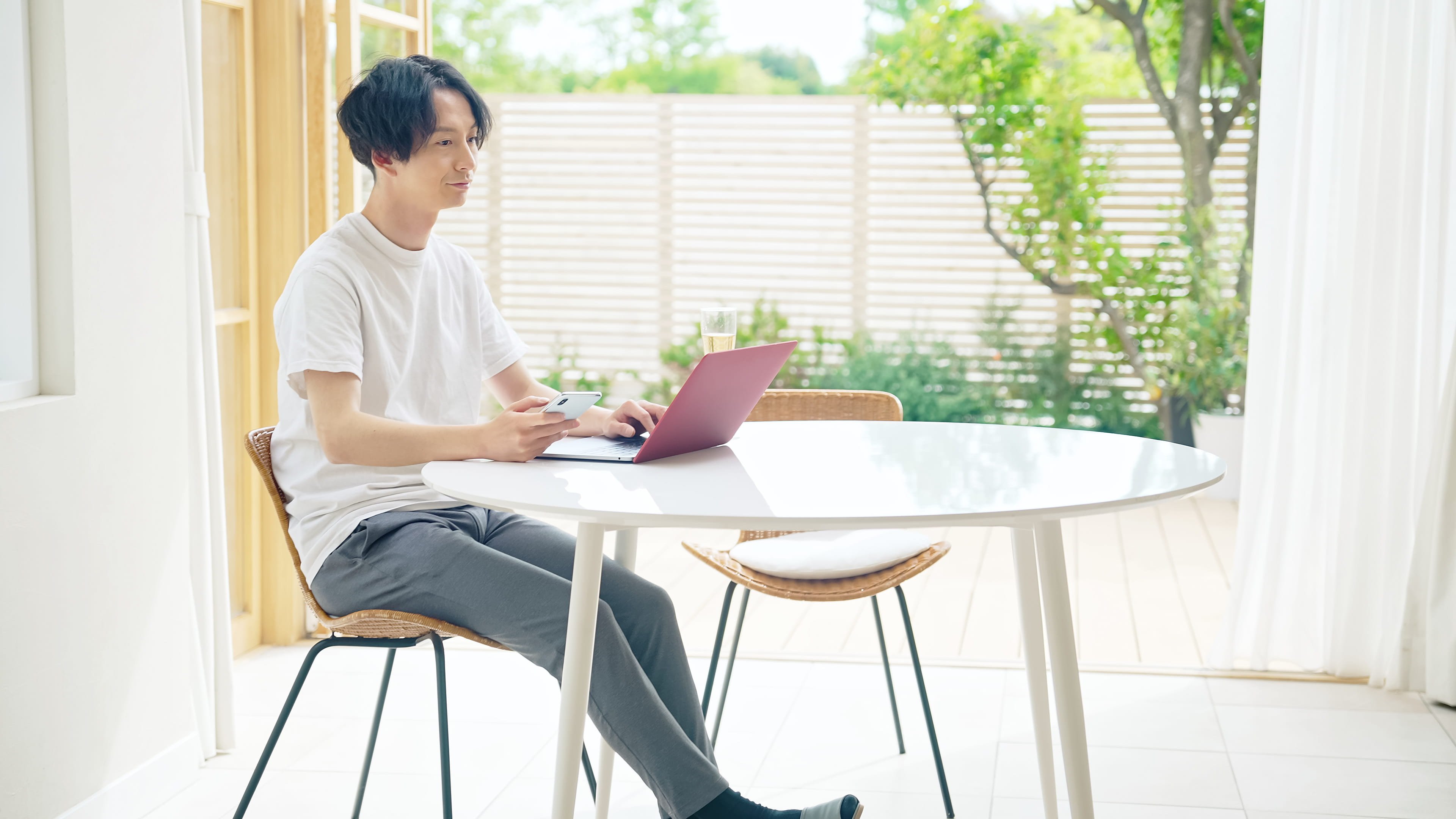 爽やかな部屋で仕事（テレワーク・ワーケーション）をする男性